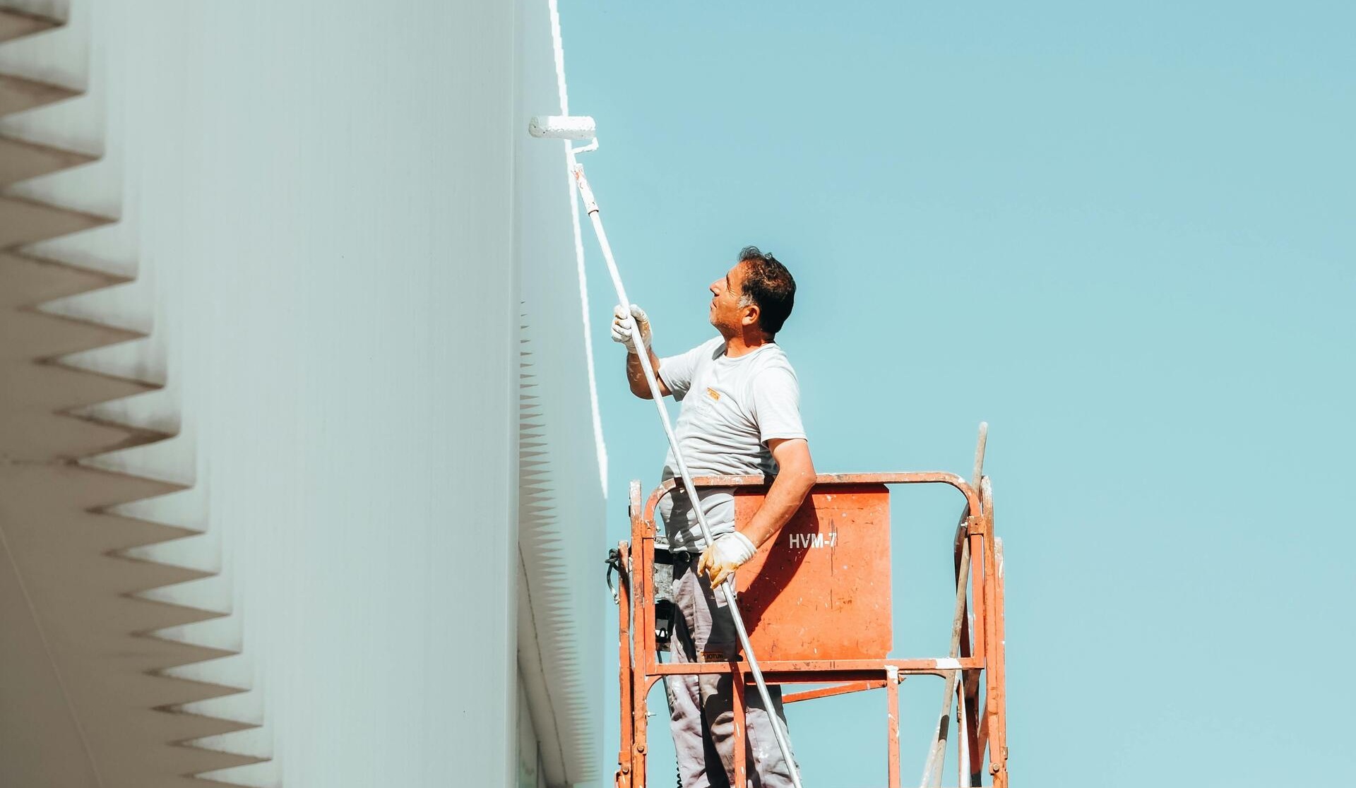 Painter on cherry picker — exterior commercial work
